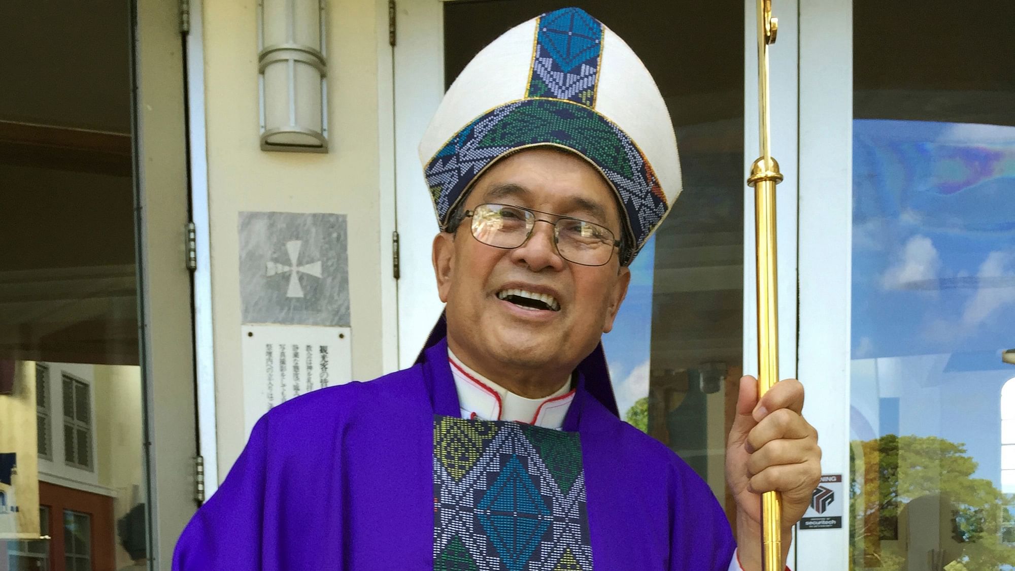 In this 30 November, 2014 file photo, Archbishop Anthony Apuron stands in front of the Dulce Nombre de Maria Cathedral Basilica in Hagatna, Guam.