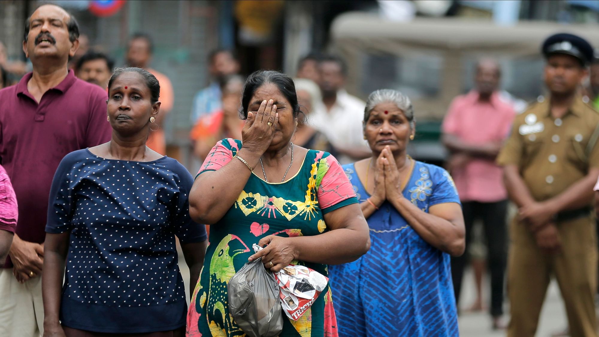 Sri Lankan Catholics pray standing on a road as they attend a brief holy service marking the seventh day of the Easter Sunday attacks near the remains of St Anthony’s Church in Colombo, Sri Lanka, on Sunday, 28 April, 2019.