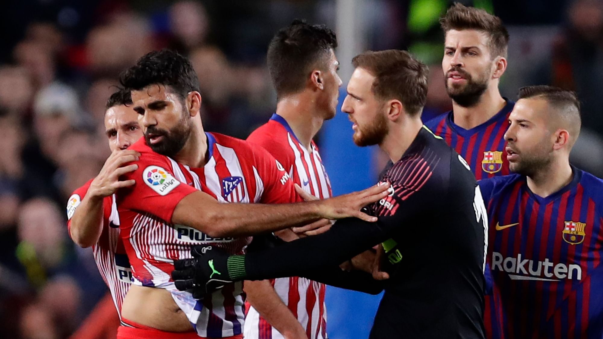 Atletico goalkeeper Jan Oblak, center right, tries to calm down teammate Diego Costa, left, after he was sent off with a red card for insulting referee Jesus Gil Manzano.