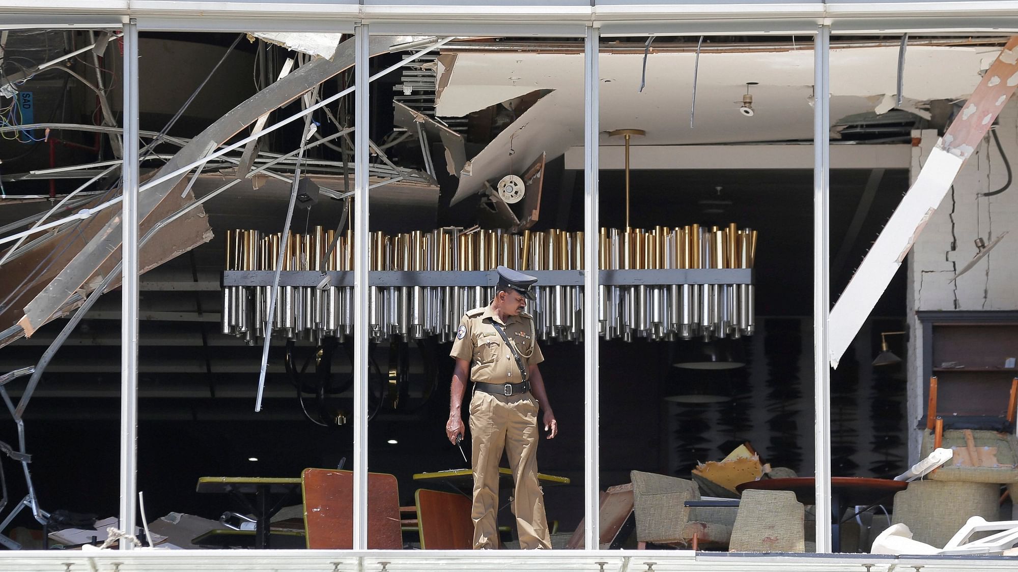 A Sri Lankan Police officer inspects a blast spot at the Shangri-La hotel in Colombo on Sunday, 21 April.