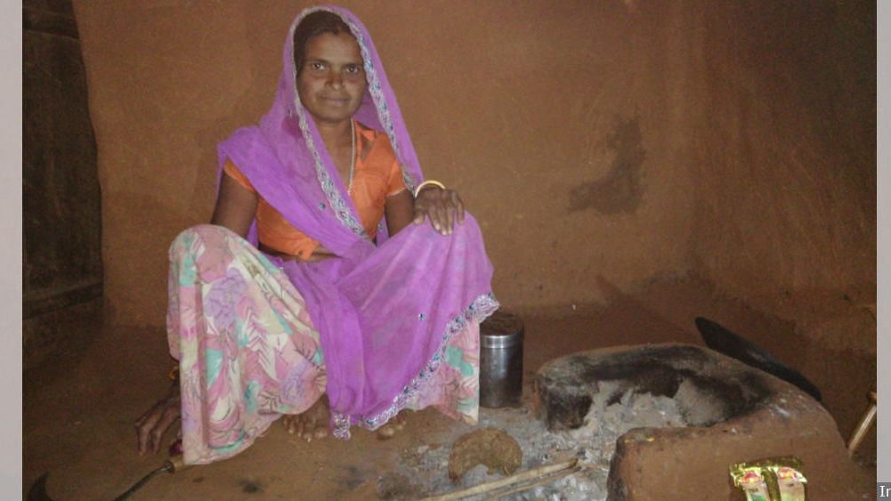Goti Bai with her earthen chulha used for everyday cooking. She received a gas stove, cylinder and regulator under PMUY but cannot afford a refill.