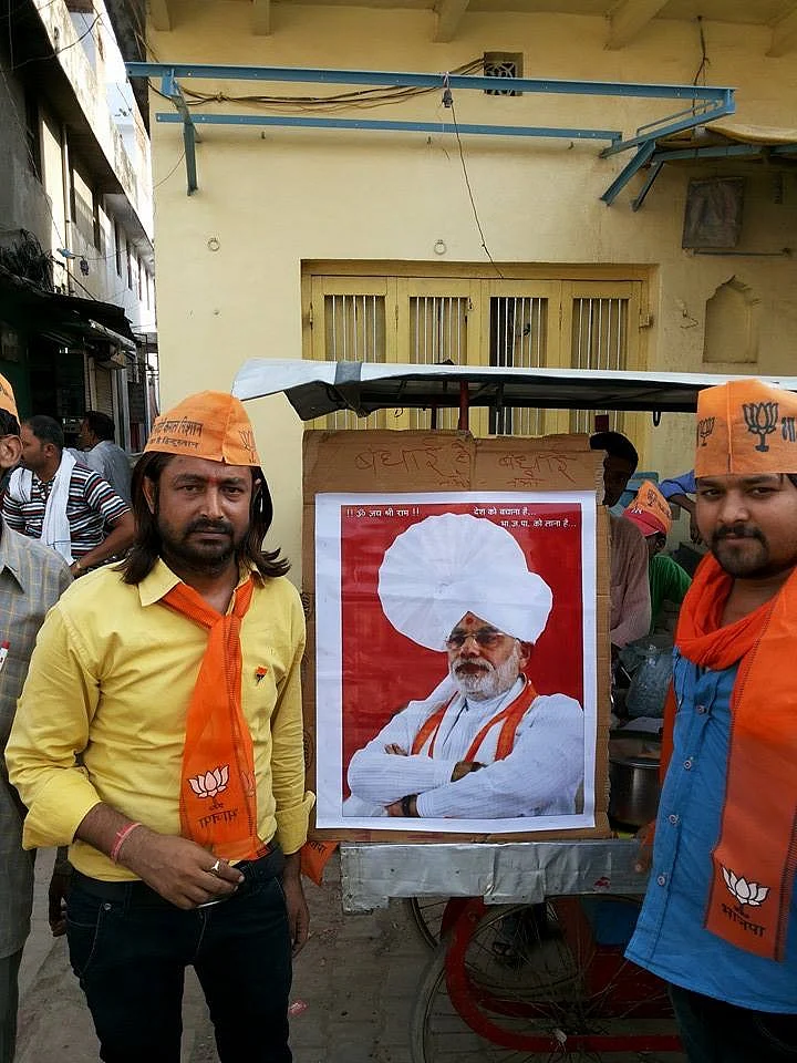 Vinay Kumar Shadeja (L) poses with a Modi poster in 2014, when he actively campaigned for the BJP in Varanasi. 