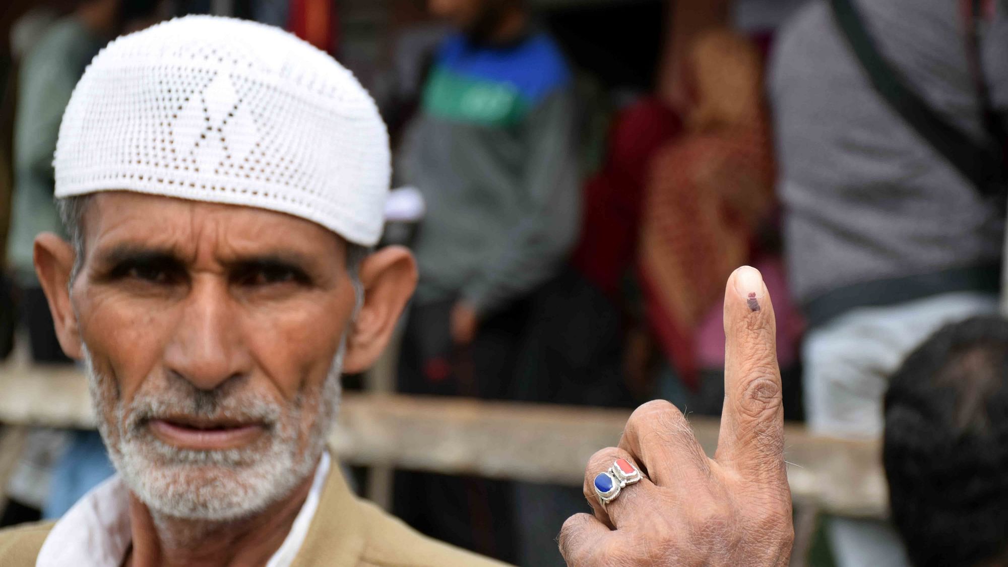 A voter showcases the inked finger after casting his vote in Baramulla