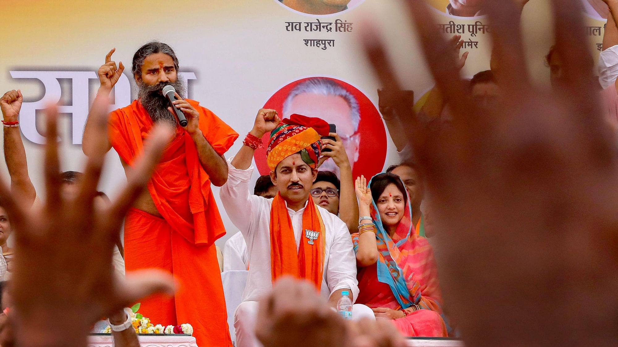 Union minister and BJP’s Jaipur Rural seat candidate Rajyavardhan Singh Rathore cheers as Yoga Guru Baba Ramdev addresses his nomination rally for the Lok Sabha polls in Jaipur.