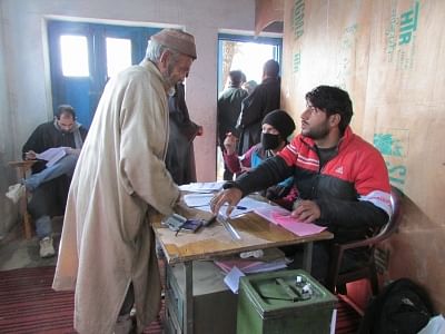 Kupwara: A man registers to cast his vote for the 7th phase of Jammu and Kashmir panchayat polls at a polling booth in Kupwara, on Dec 4, 2018. (Photo: IANS)