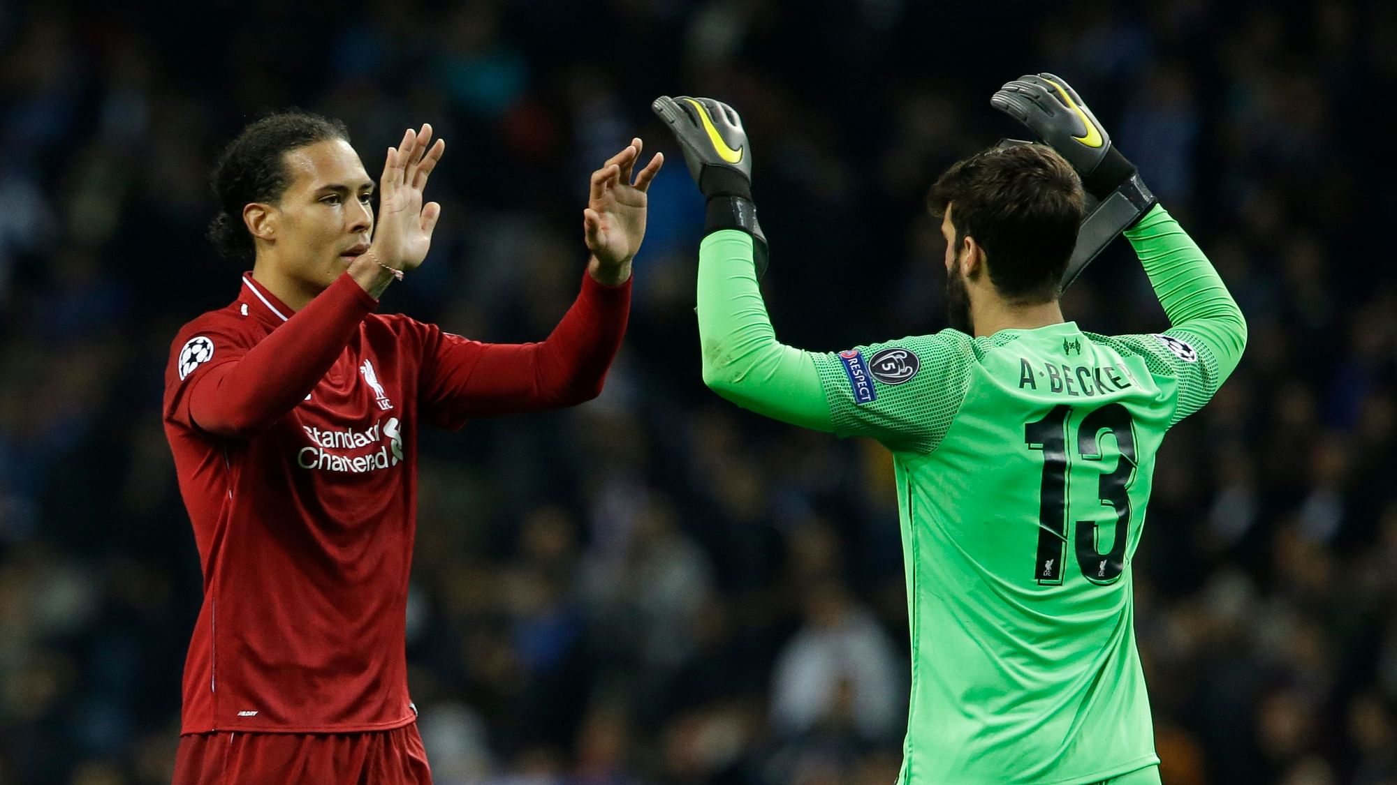 Virgil Van Dijk celebrates with teammate Alison Becker after a win during the UEFA Champions League.