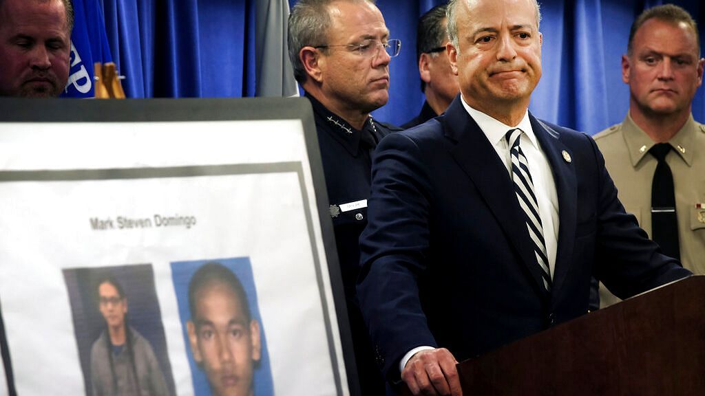United States Attorney Nick Hanna stands next to photos of Mark Steven Domingo during a news conference in Los Angeles on Monday.