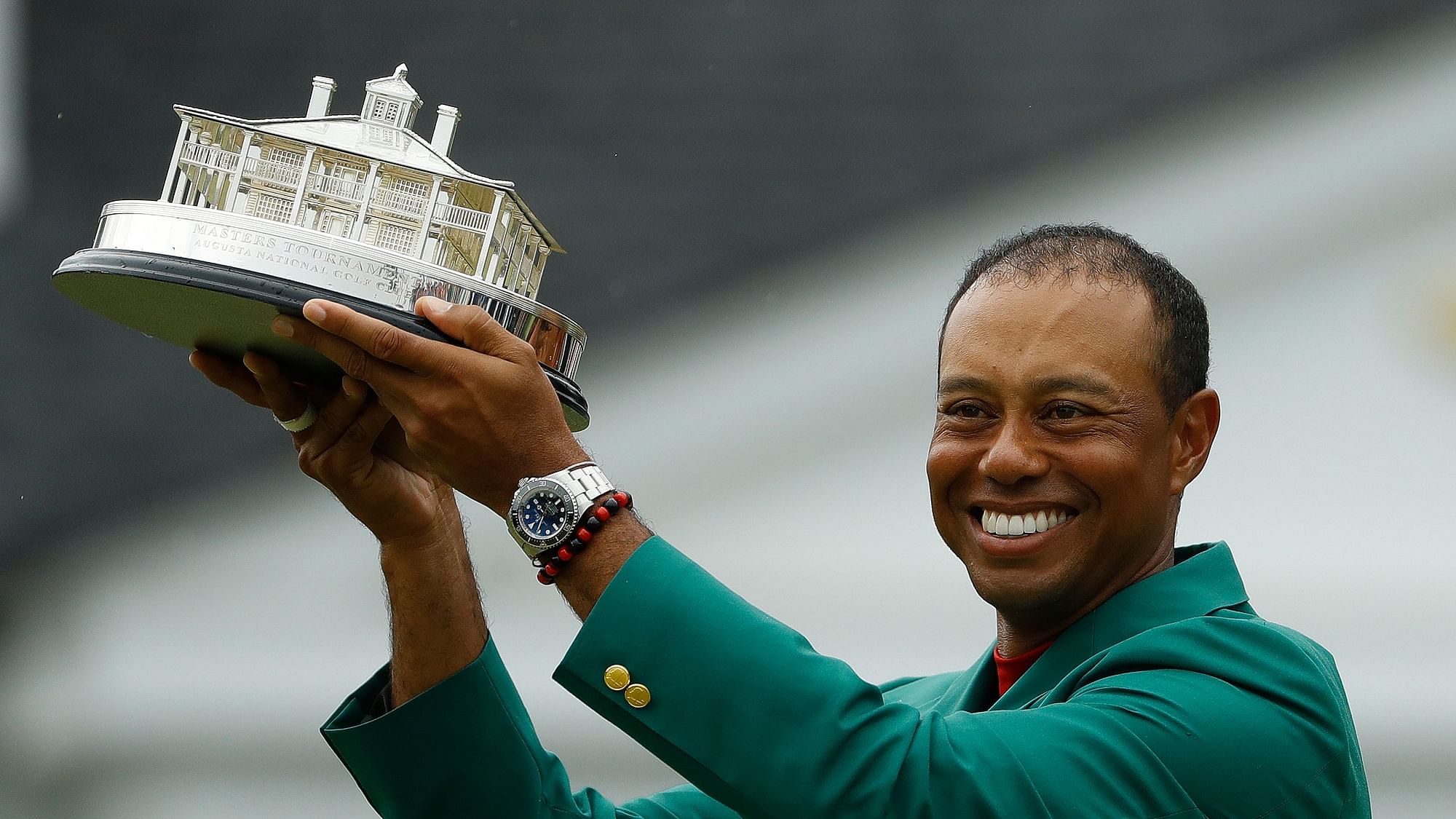 Tiger Woods wears his green jacket holding the winning trophy after the final round for the Masters golf tournament.