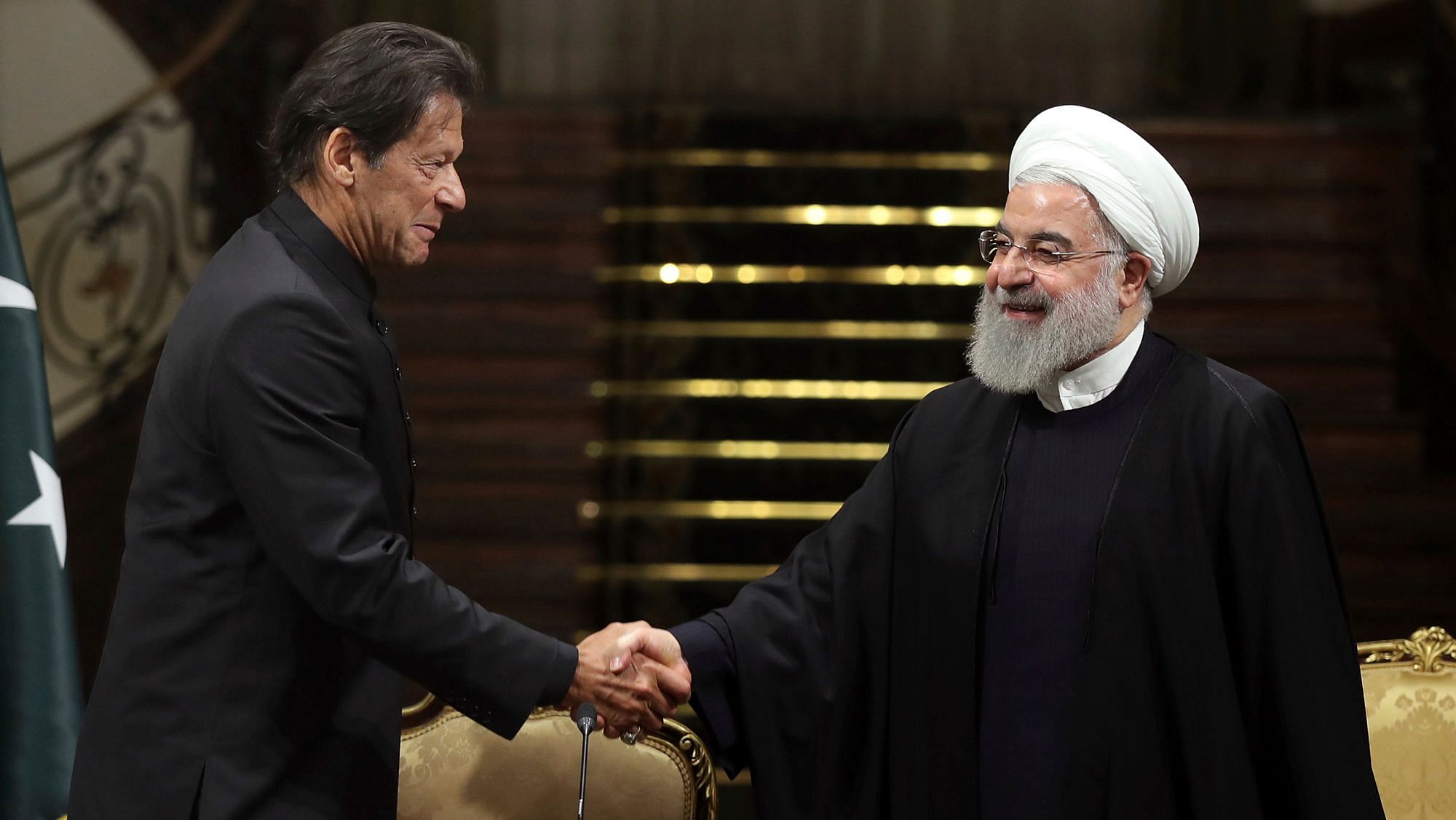 Iran’s President Hassan Rouhani and Pakistani Prime Minister Imran Khan, shake hands after a joint press briefing at the Saadabad Palace in Tehran.