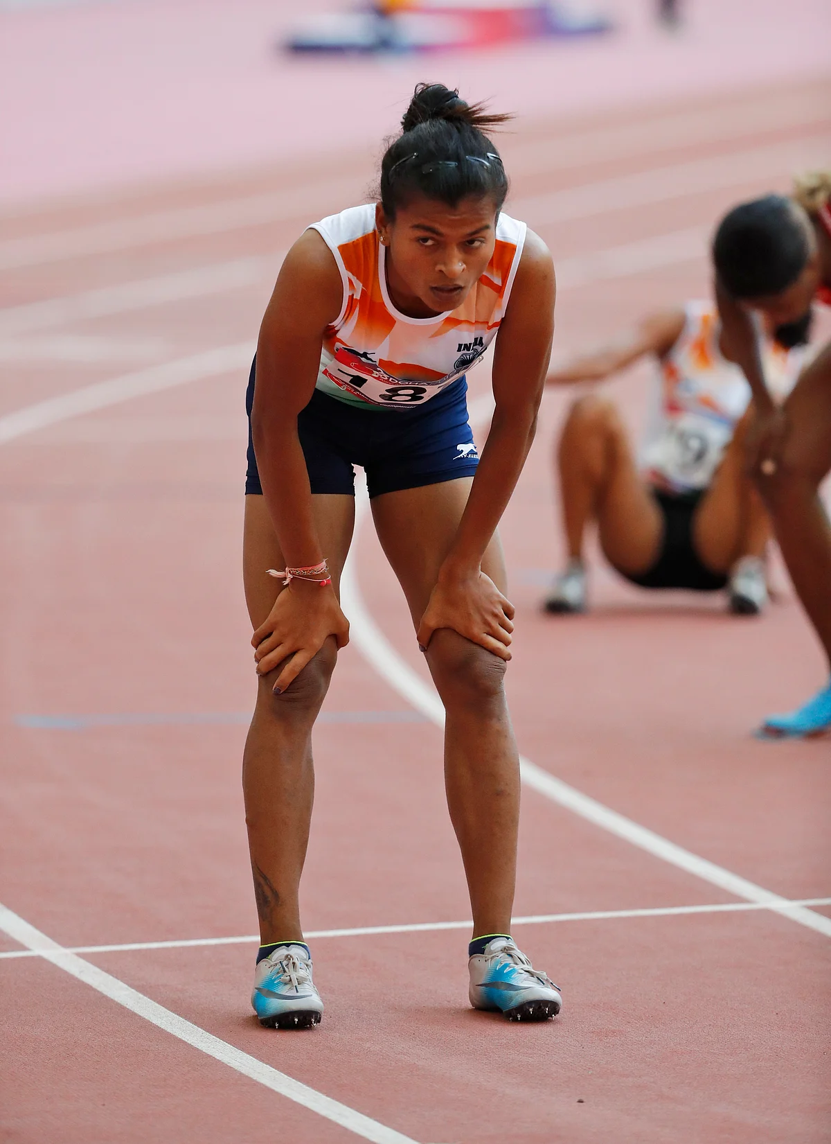 Saritaben Laxmanbhai Gayakwad rests after racing in the women’s 400-meters hurdles final at the Asian Athletics Championships.