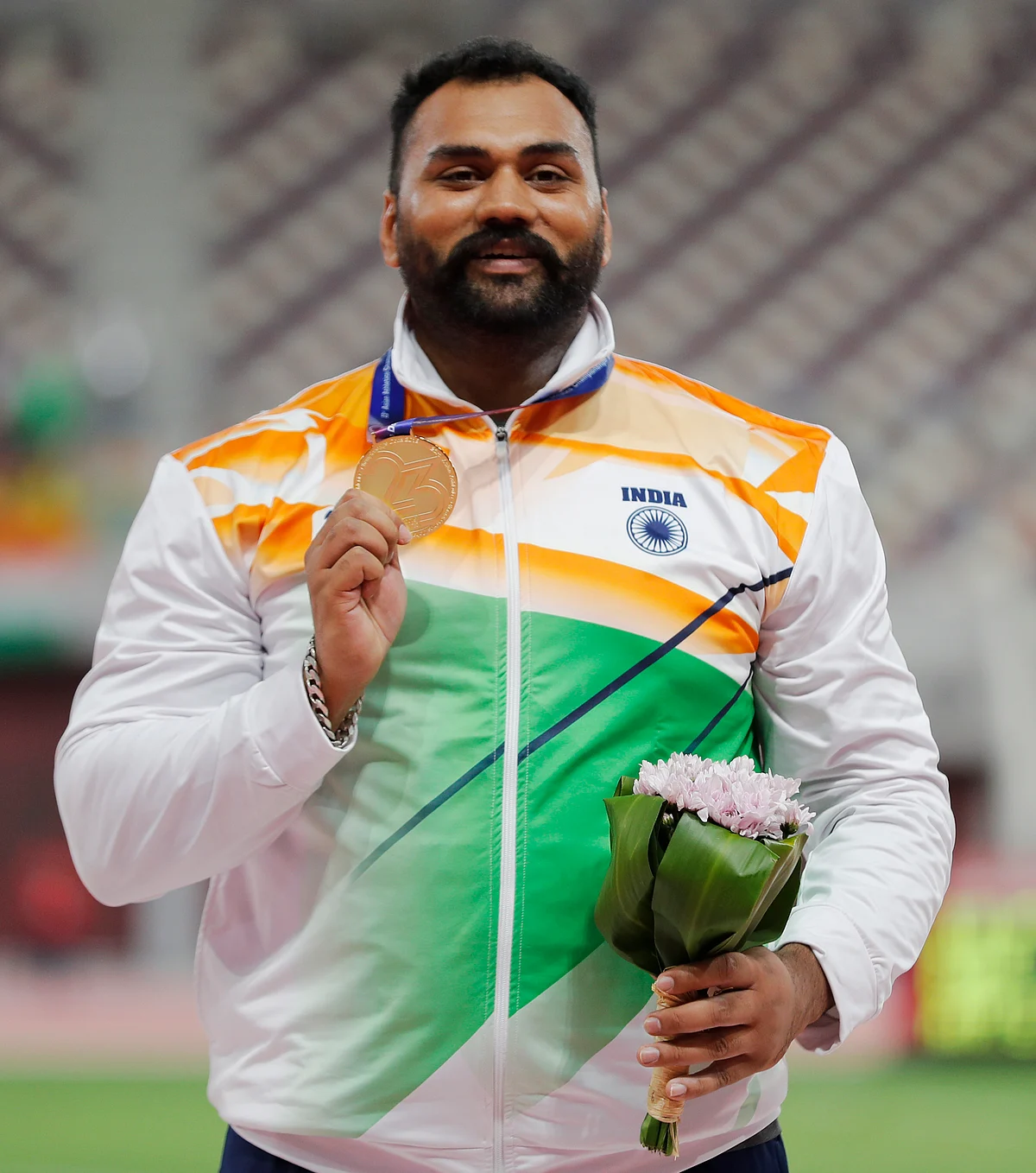 Tejinderpal Singh Toor celebrates after winning the gold medal.