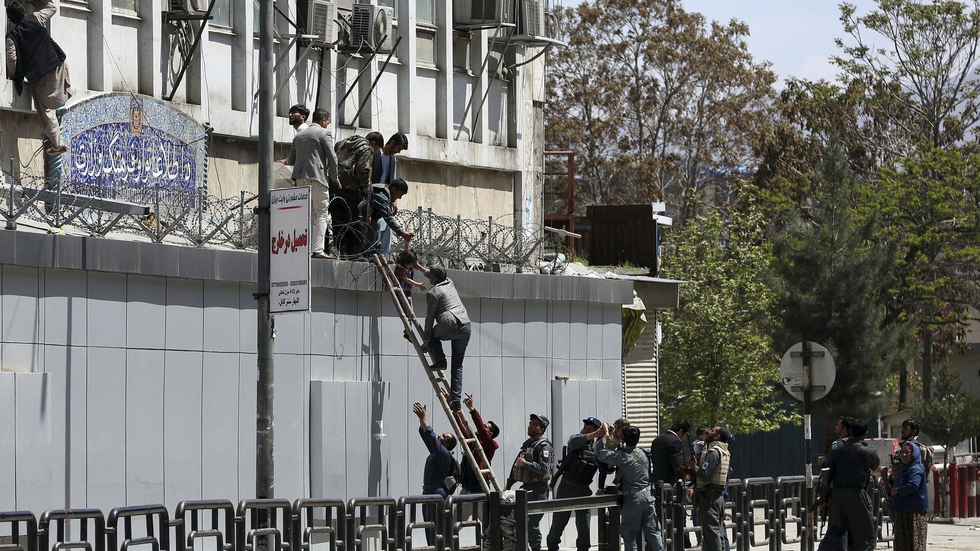 Afghan security personnel rescue men and children from the information and culture ministry after an attack near to the Telecommunication Ministry in Kabul, Afghanistan.