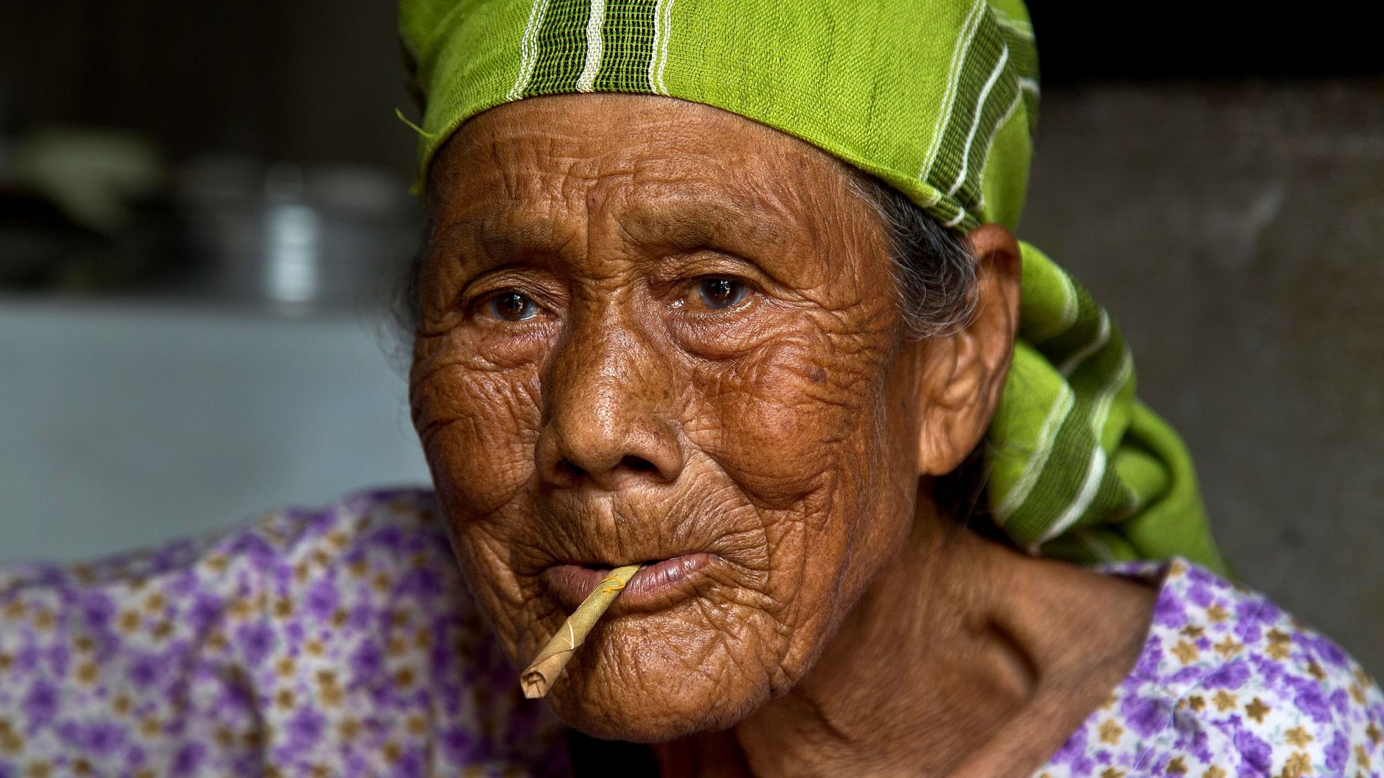 Bum Nongrum, 91, smokes a beedi, tobacco rolled in an indigenously available leaf, at her house in Nongpoh, Meghalaya.&nbsp;