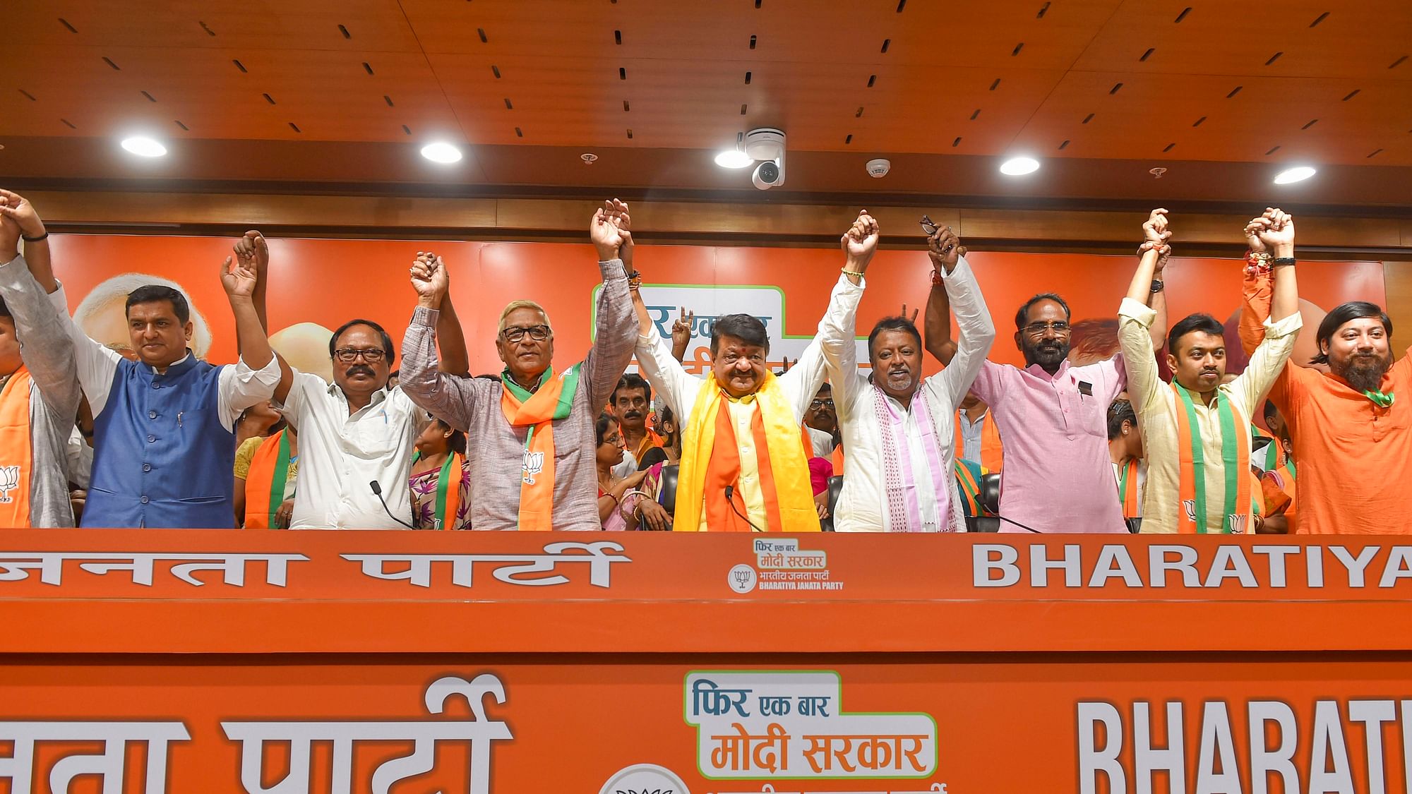 BJP leaders Kailash Vijaivargiya and Mukul Roy join hands with two Trinamool Congress and one CPM legislator, who joined Bharatiya Janata Party along with 60 councillors from three civic bodies in West Bengal, in New Delhi, Tuesday, 28 May 2019.