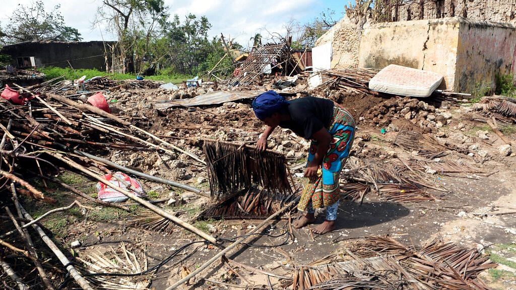 A woman picks up pieces from her house which was damaged by Cyclone Kenneth in Mozambique on 1 May.