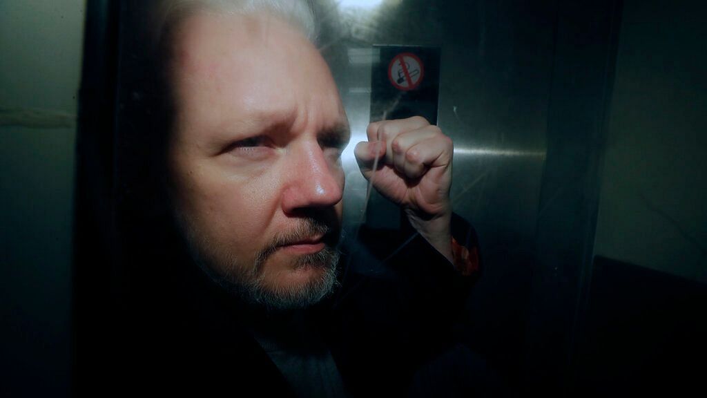 WikiLeaks founder Julian Assange puts his fist up as he is taken from court in London.&nbsp;&nbsp;