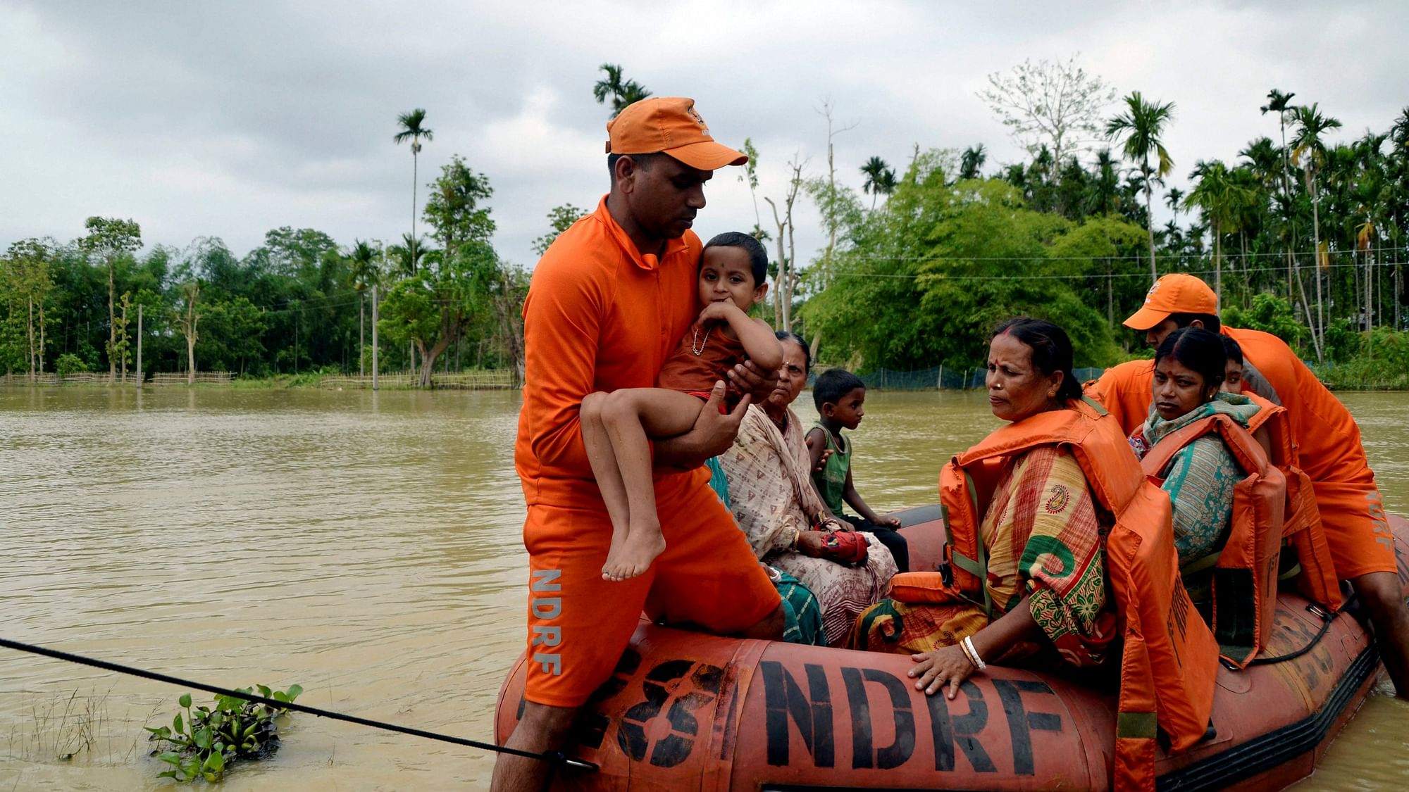 NDRF rescue personnel carry a young girl from a submerged area to safer places at Dharmanagar, in Tripura.