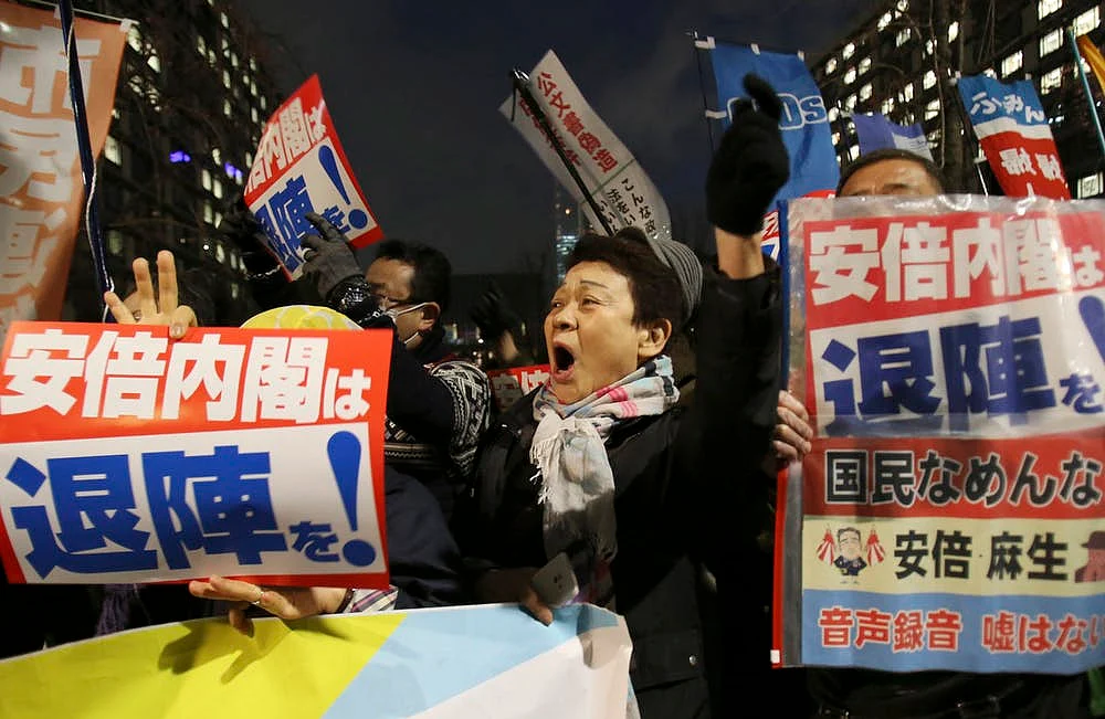 Anti-Abe protesters in Tokyo hold signs calling for Abe’s resignation after his administration was ensnared in a corruption scandal, March 23, 2018.