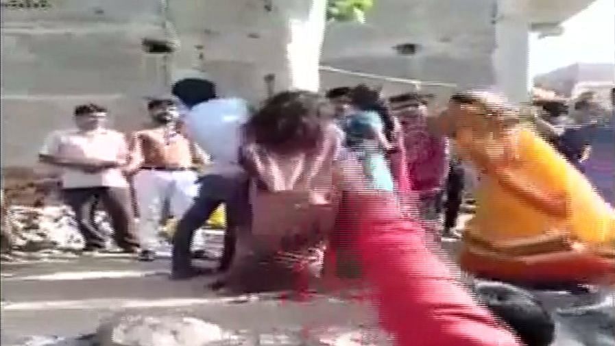 Three people tied to a tree and being beaten up in Arjun colony.