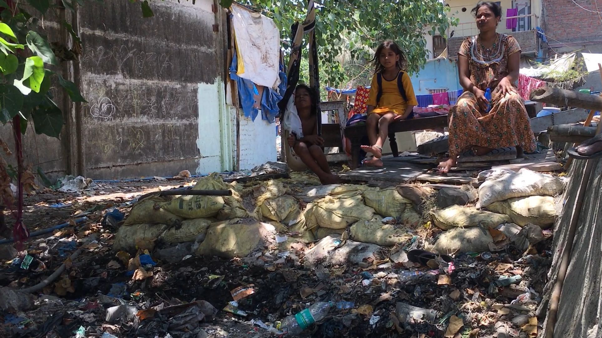 Slum dwellers sit next to a nullah in Mumbai’s Wadala area.