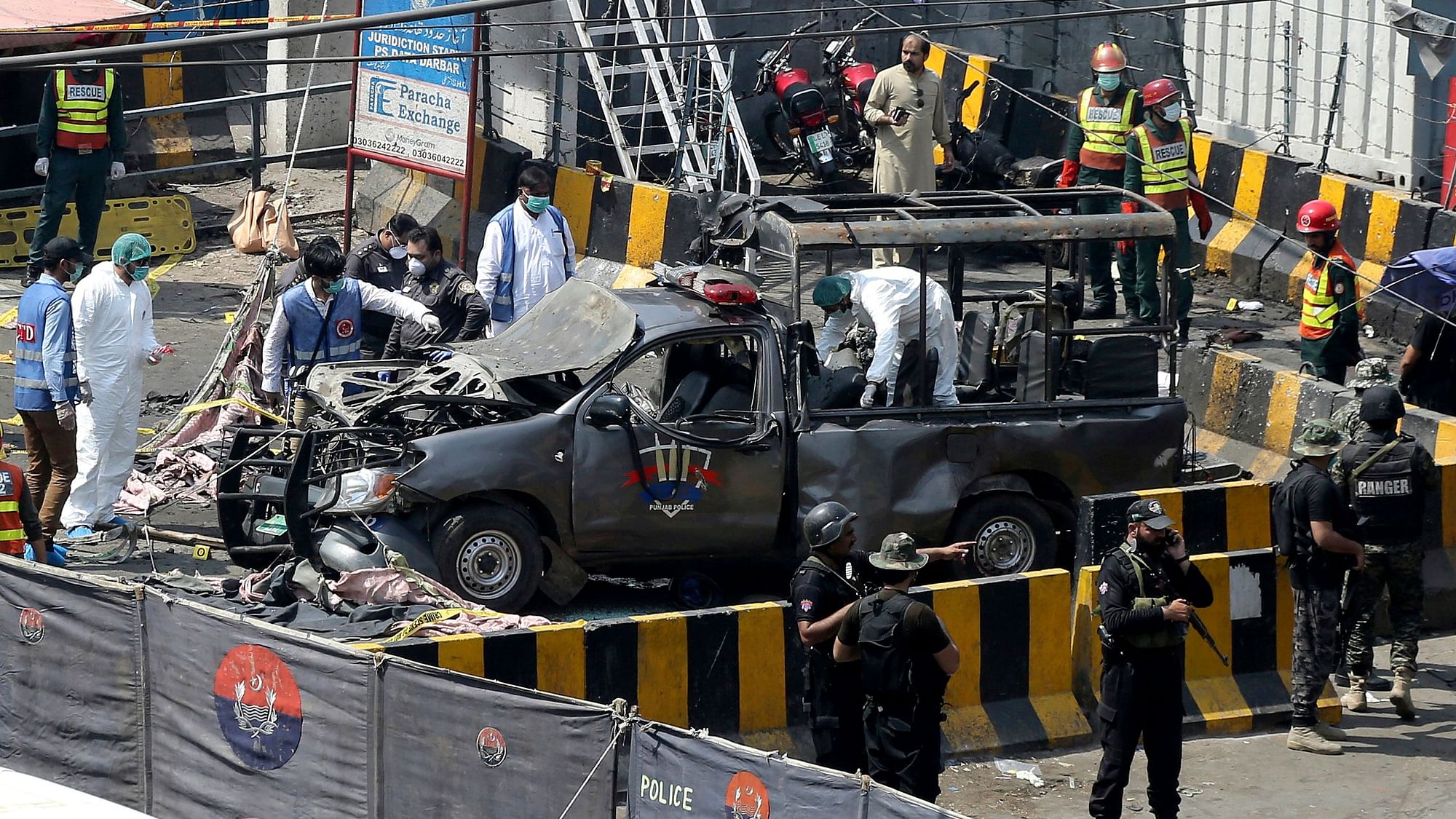 Pakistani security personnel surround a damaged police van in Lahore, Pakistan, Wednesday, May 8, 2019.