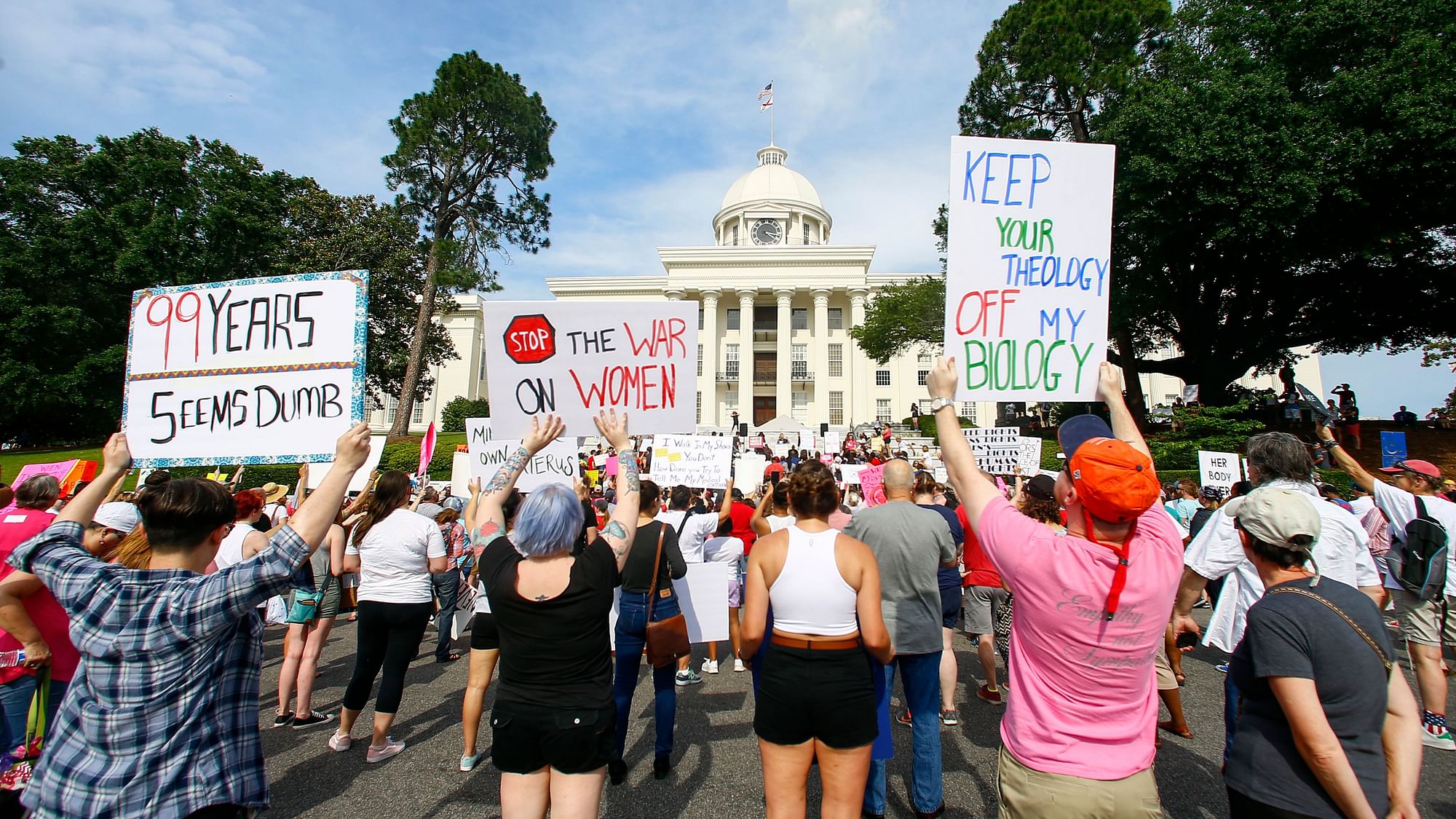 Protesters for women’s rights hold a rally on the Alabama Capitol steps to protest a law passed last week making abortion a felony in nearly all cases with no exceptions for cases of rape or incest.