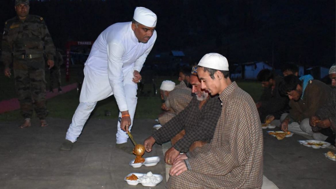 An army Panditji<i> </i>(priest) serves food to local civilians during Iftar at Dawar, Gurez in North Kashmir.