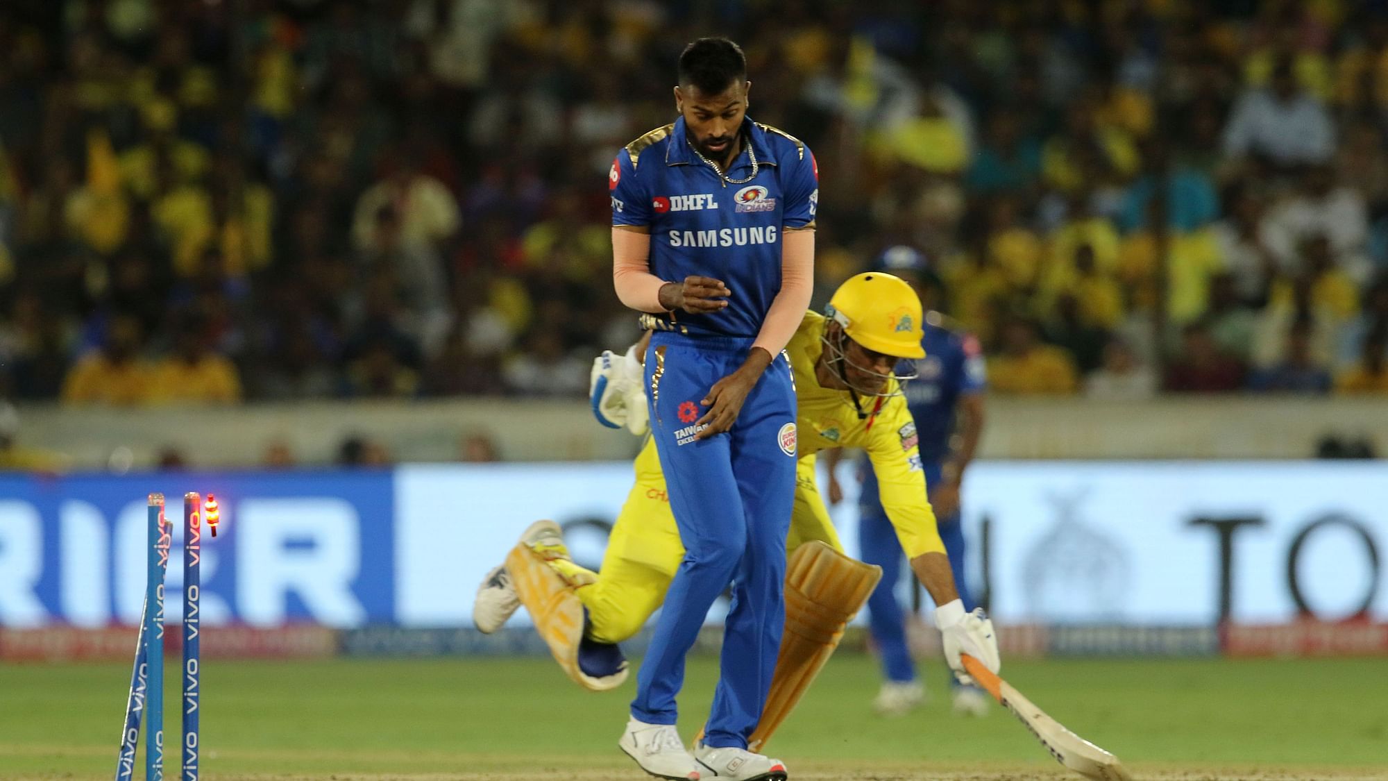 Chennai Super King’s captain Mahendra Singh Dhoni, center, runs unsuccessfully to make it to the crease as the bails fall during the IPL final match between Mumbai Indians and Chennai Super Kings.