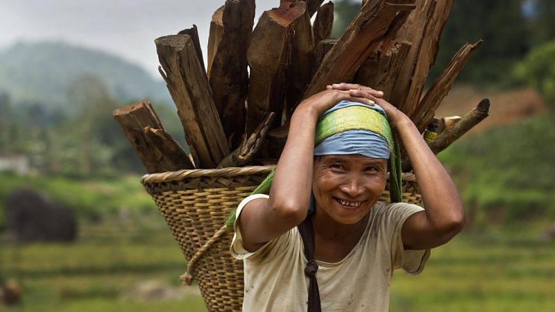 A Khasi tribal woman Lona Syngkli carries firewood in a basket swung around her head in Nongpoh, Meghalaya. Syngkli says she knows nothing about politics but cast her vote because her husband told her to.&nbsp;