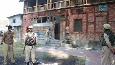 File photo of security personnel standing guard outside a polling booth in Jammu and Kashmir.