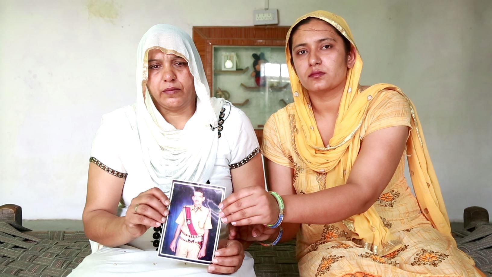 Sunita and her eldest Monika hold up a photo of late Jagbir Singh Rana.