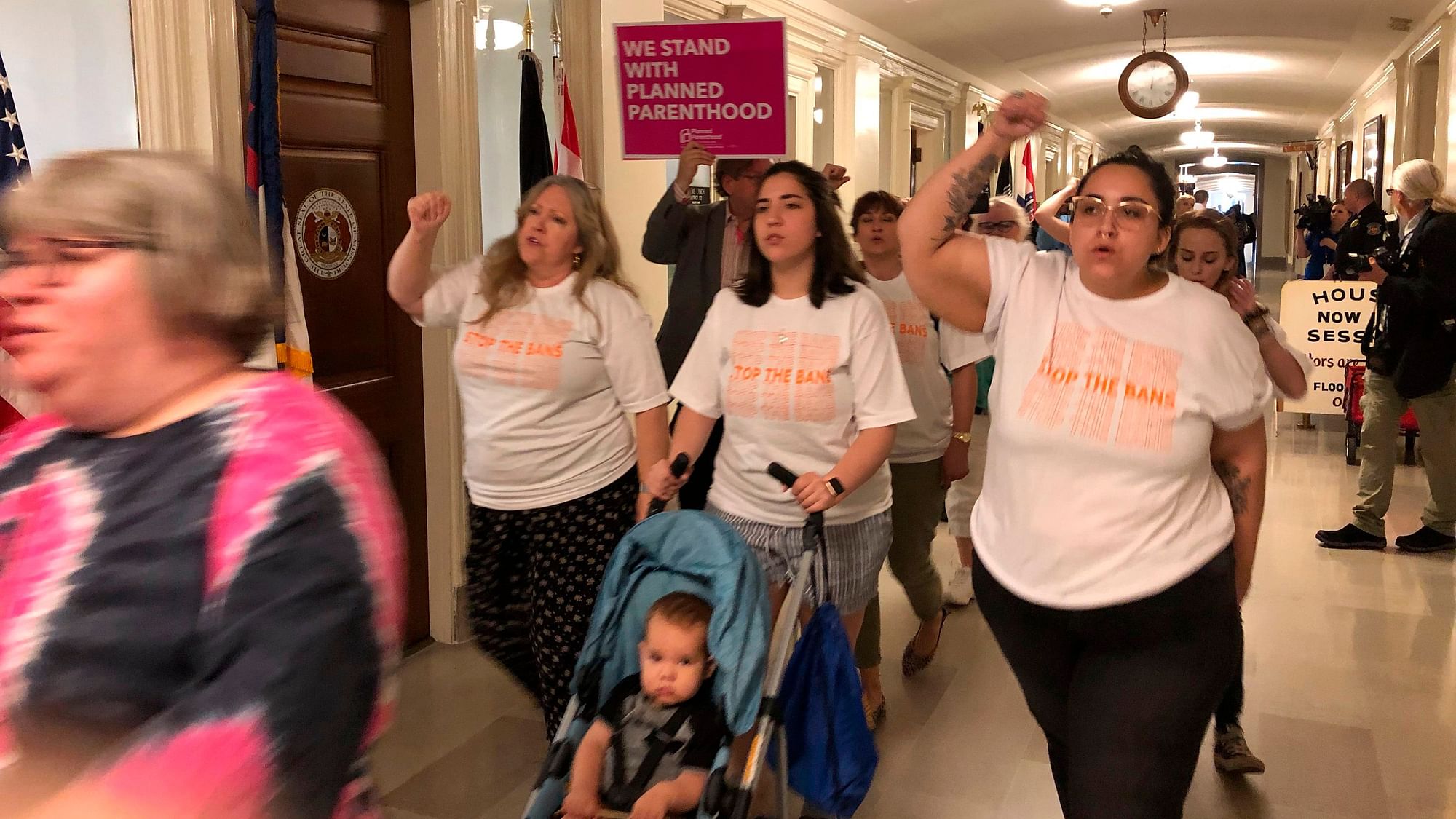Protesters march through the halls of the Missouri Capitol outside the House chamber on Friday, May 17, 2019, in Jefferson City, Missouri, in opposition to legislation prohibiting abortions at eight weeks of pregnancy.