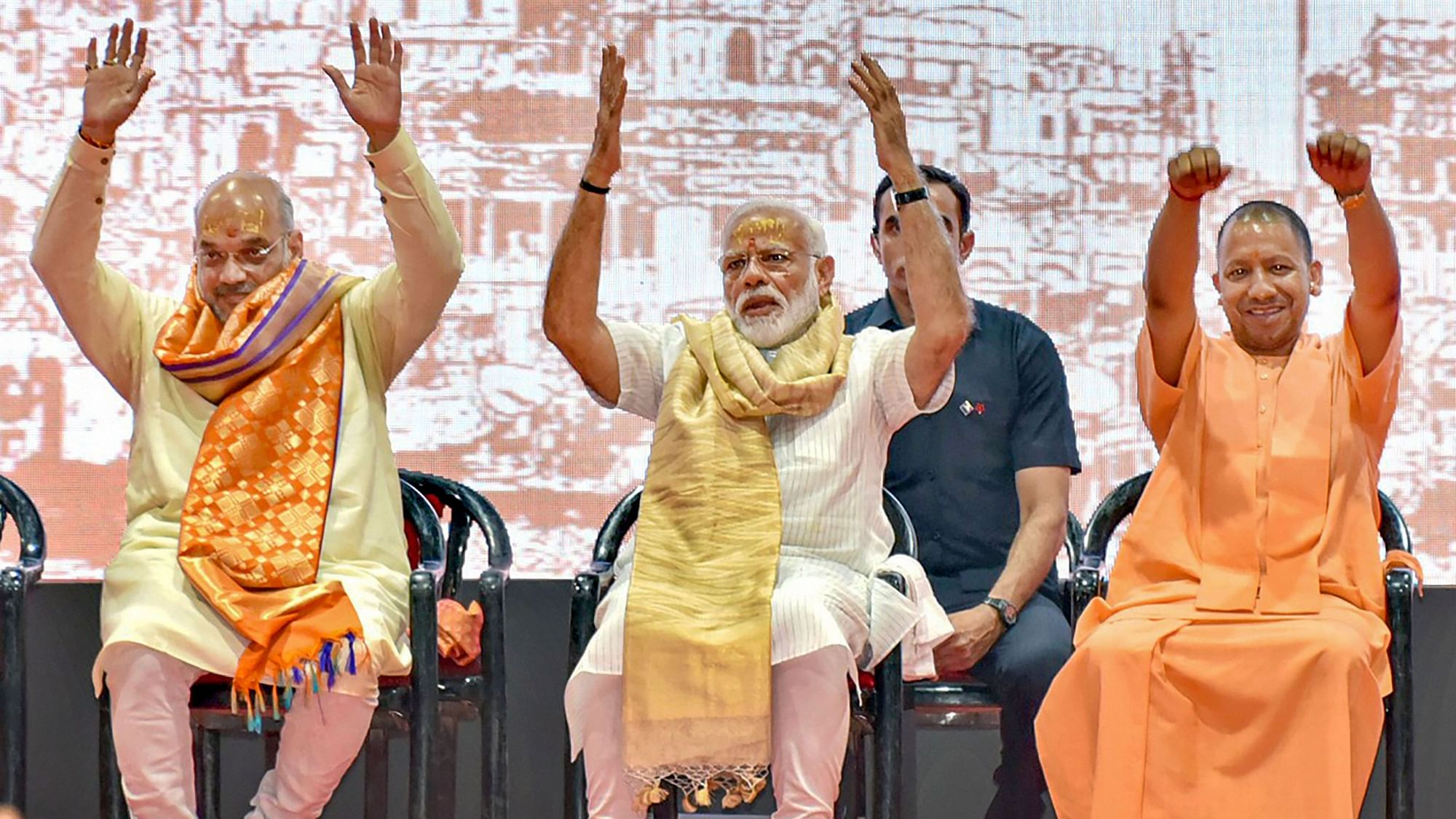 PM Modi (centre), along with Uttar Pradesh CM Yogi Adityanath (right) and BJP President Amit Shah (left) greets BJP workers in Varanasi.