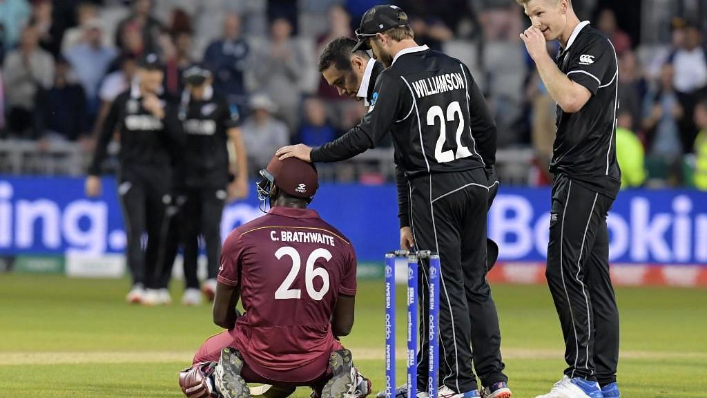 As dismissed Carlos Brathwaite sits on the pitch in disappointment, New Zealand skipper, who scored a century in the previous match, comes to console him.