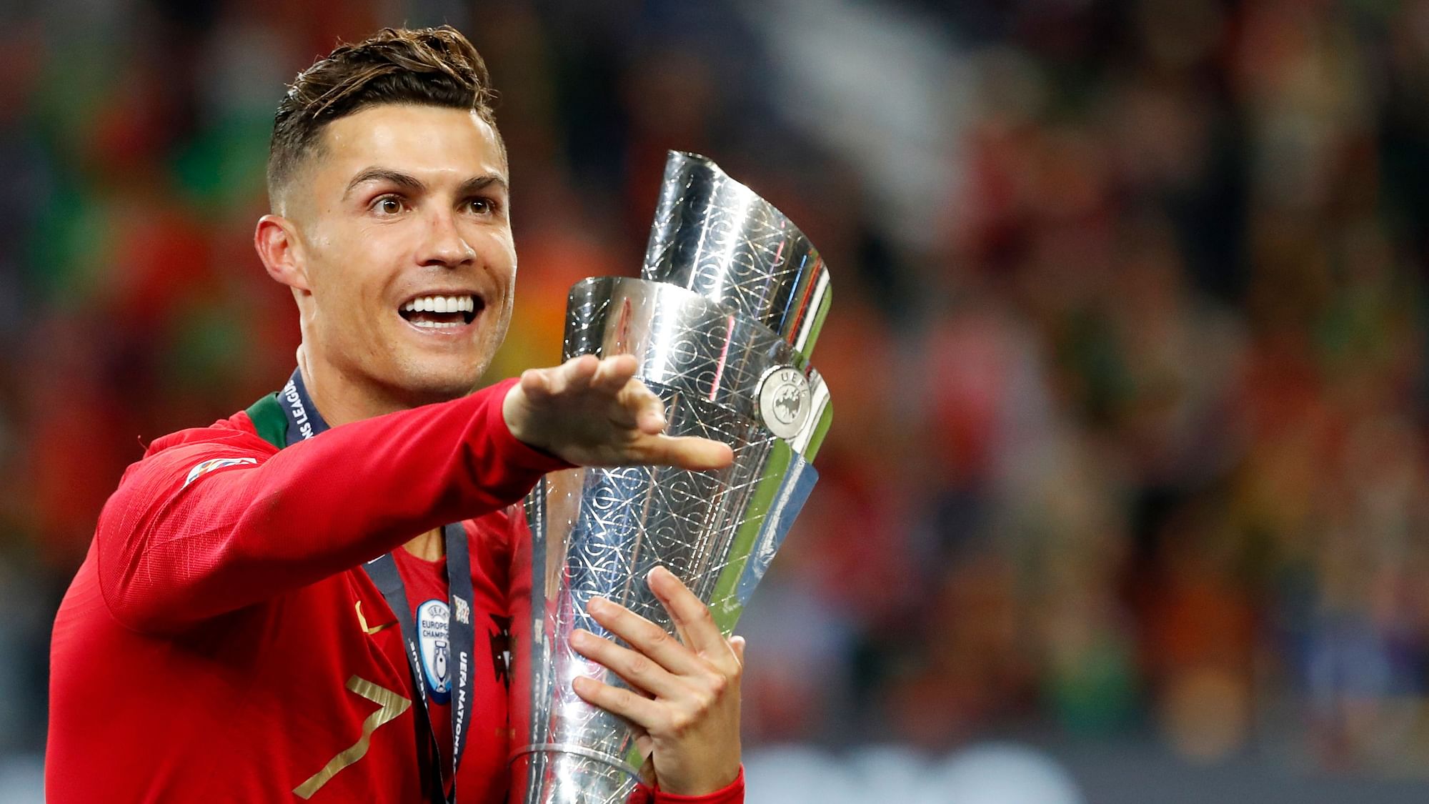 Portugal’s Cristiano Ronaldo gestures as he holds the trophy after defeating the Netherlands 1-0 in the UEFA Nations League final soccer match.
