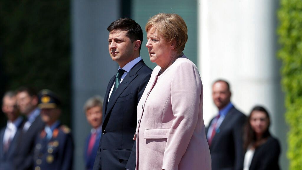 German Chancellor Angela Merkel (right) trembles strong as she and Ukraine’s President Volodymyr Zelenskiy, (left) attend the national anthems as part of a military welcome ceremony in Berlin, Germany, Tuesday, 18 June, 2019.