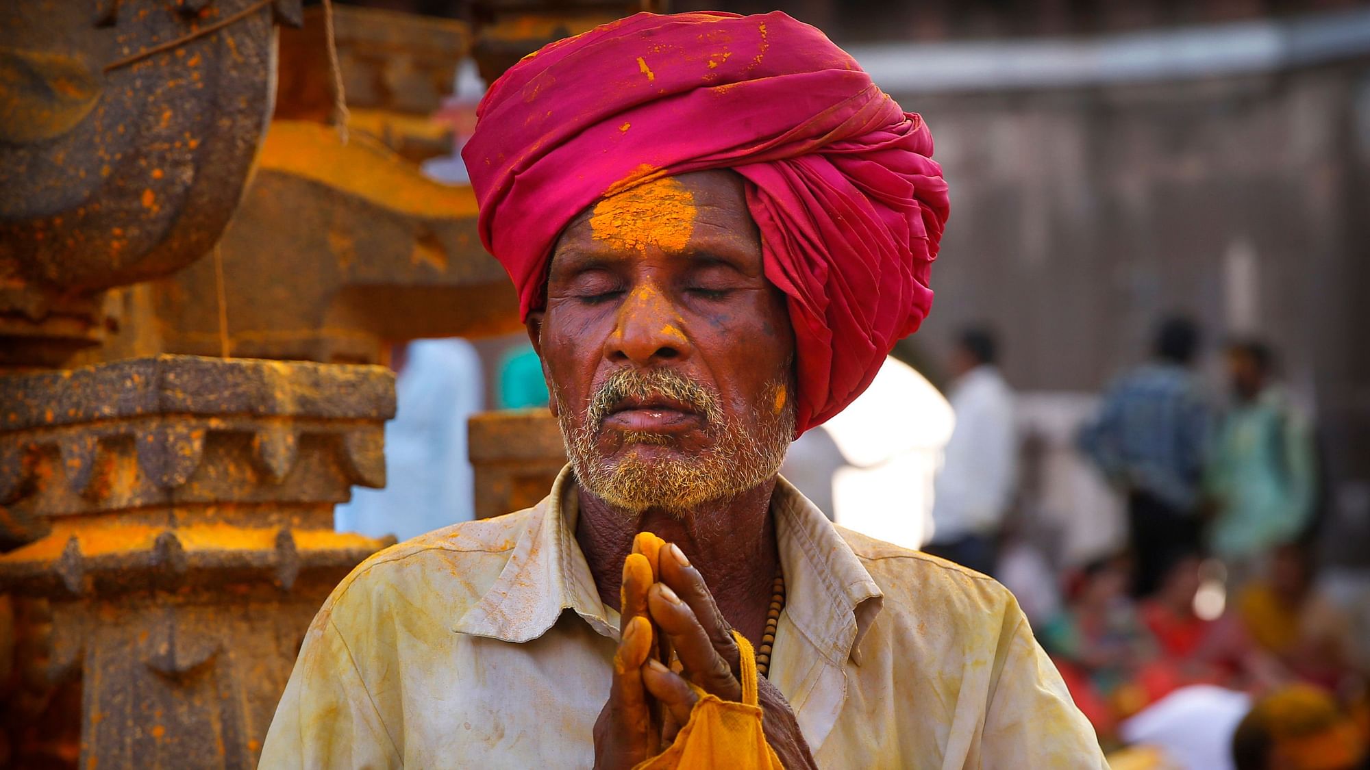 A devotee smeared in  turmeric prays during the celebration of the Bhandara Festival at the Jejuri temple in Pune.&nbsp;