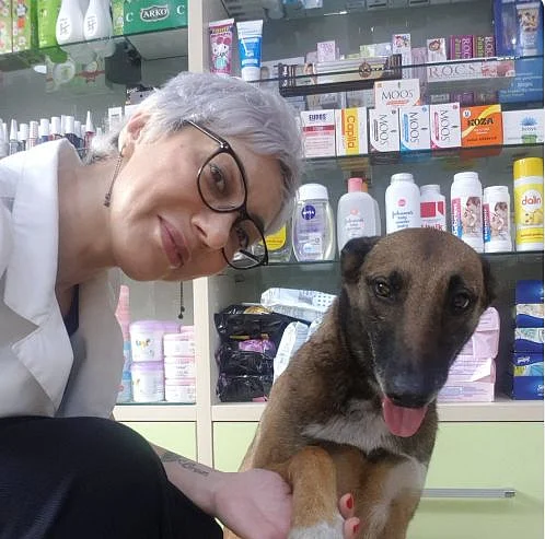Banu Cengiz holding the dog's paw. 