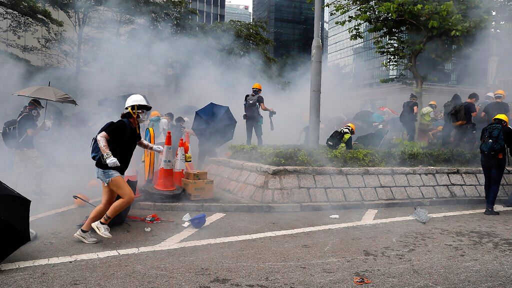 Protesters react to tear gas during a large protest near the Legislative Council in Hong Kong on 12 June 2019. &nbsp;