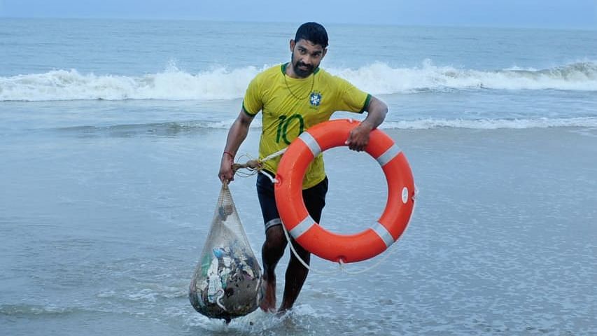 Priyesh KV cleaning plastic from the sea.