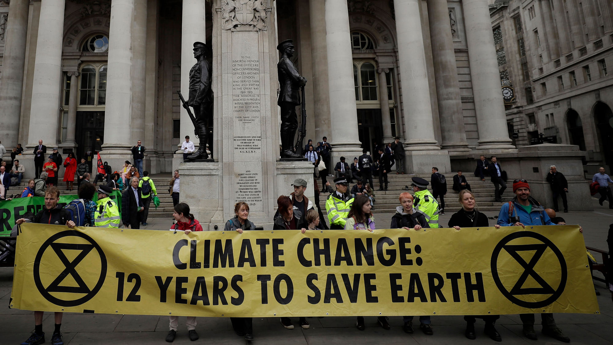 In this Thursday, April 25, 2019 file photo, Extinction Rebellion climate change protesters hold up a banner near the Bank of England, in the City of London.