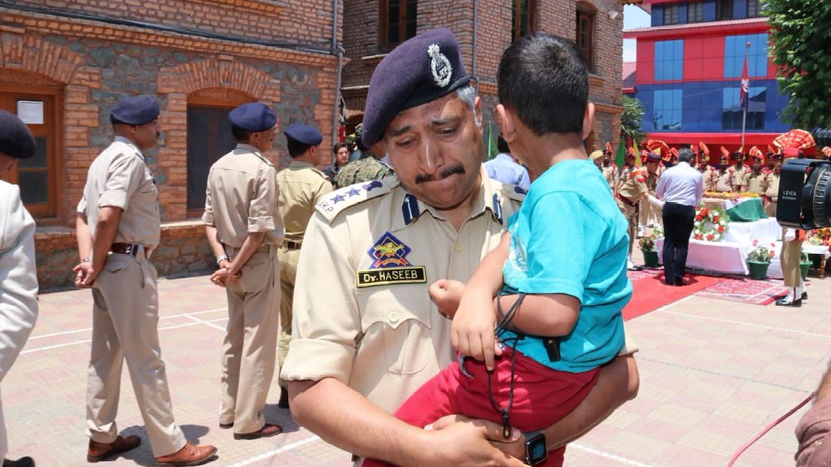 SSP Srinagar M Haseeb Mughal carried martyred cop Arshad Khan’s son during his wreath-laying ceremony.