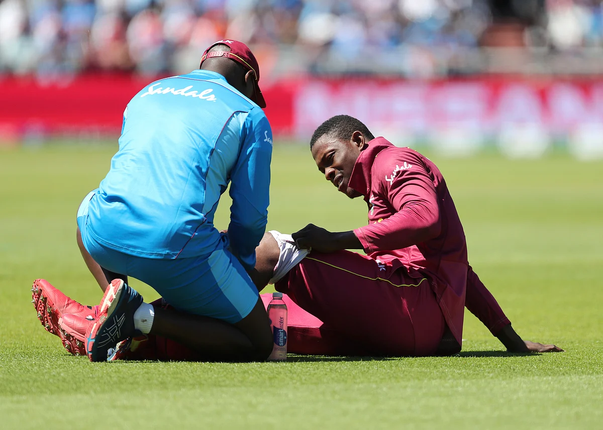 A member of team support staff attends to West Indies’ Sheldon Cottrell during the Cricket World Cup match between India and West Indies.