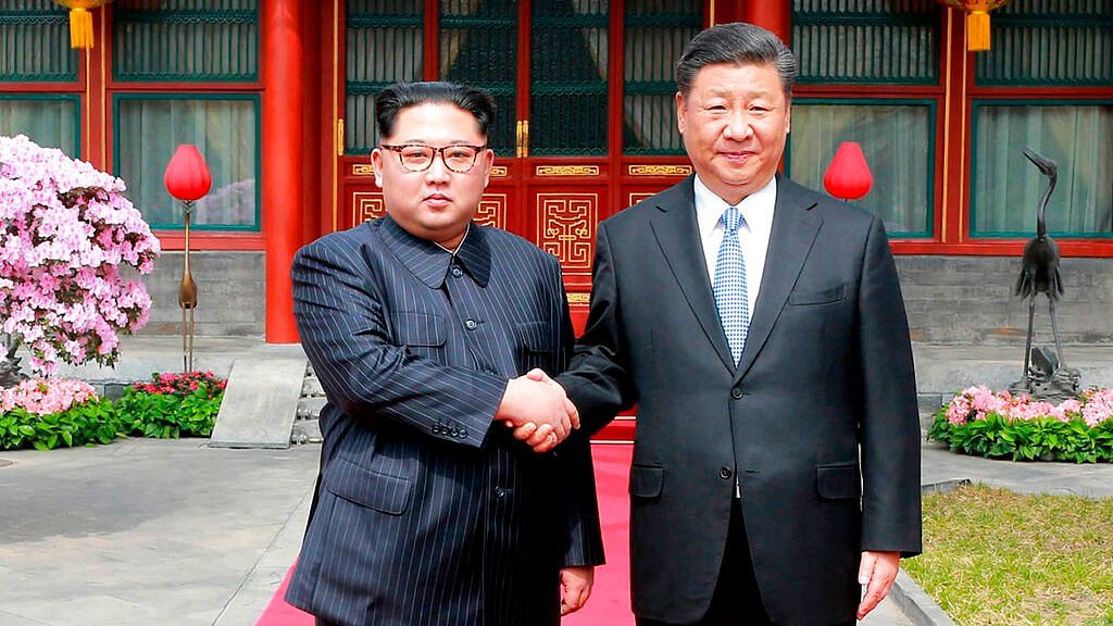 In this 27 March 2018 photo, North Korean Leader Kim Jong Un (L), shakes hands with Chinese counterpart Xi Jinping at Diaoyutai State Guesthouse in Beijing.