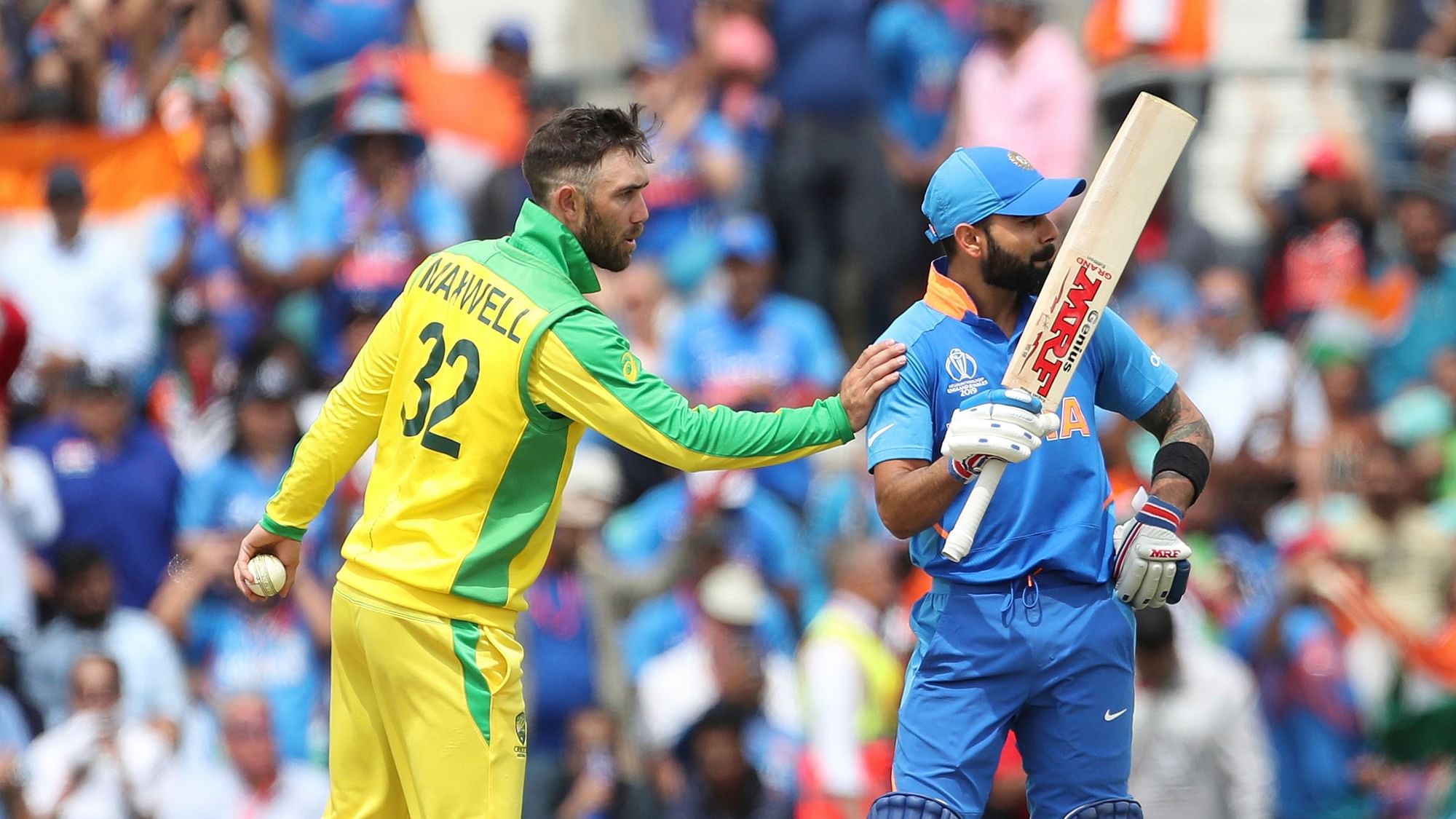 India's captain Virat Kohli, right, celebrates scoring fifty runs as Australia's Glenn Maxwell asks him to move on the other side of wicket to let him bowl during the Cricket World Cup match between Australia and India at The Oval in London, Sunday, June 9, 2019. 