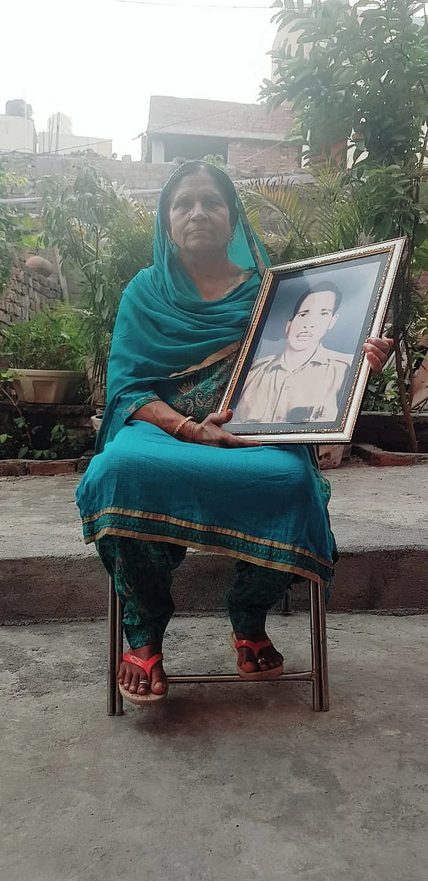Rani Devi holding a picture of her missing husband, Sepoy Jagdish Lal.
