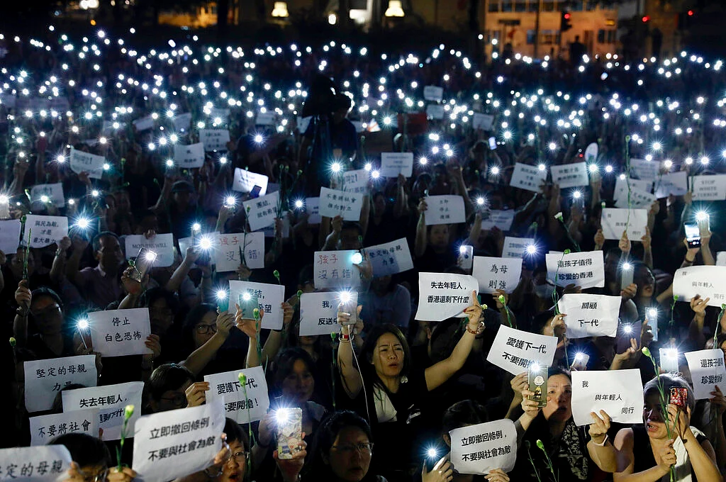 Hundreds of mothers holding placards and lit smartphones protest against the amendments to the extradition law in Hong Kong on 14 June 2019. 