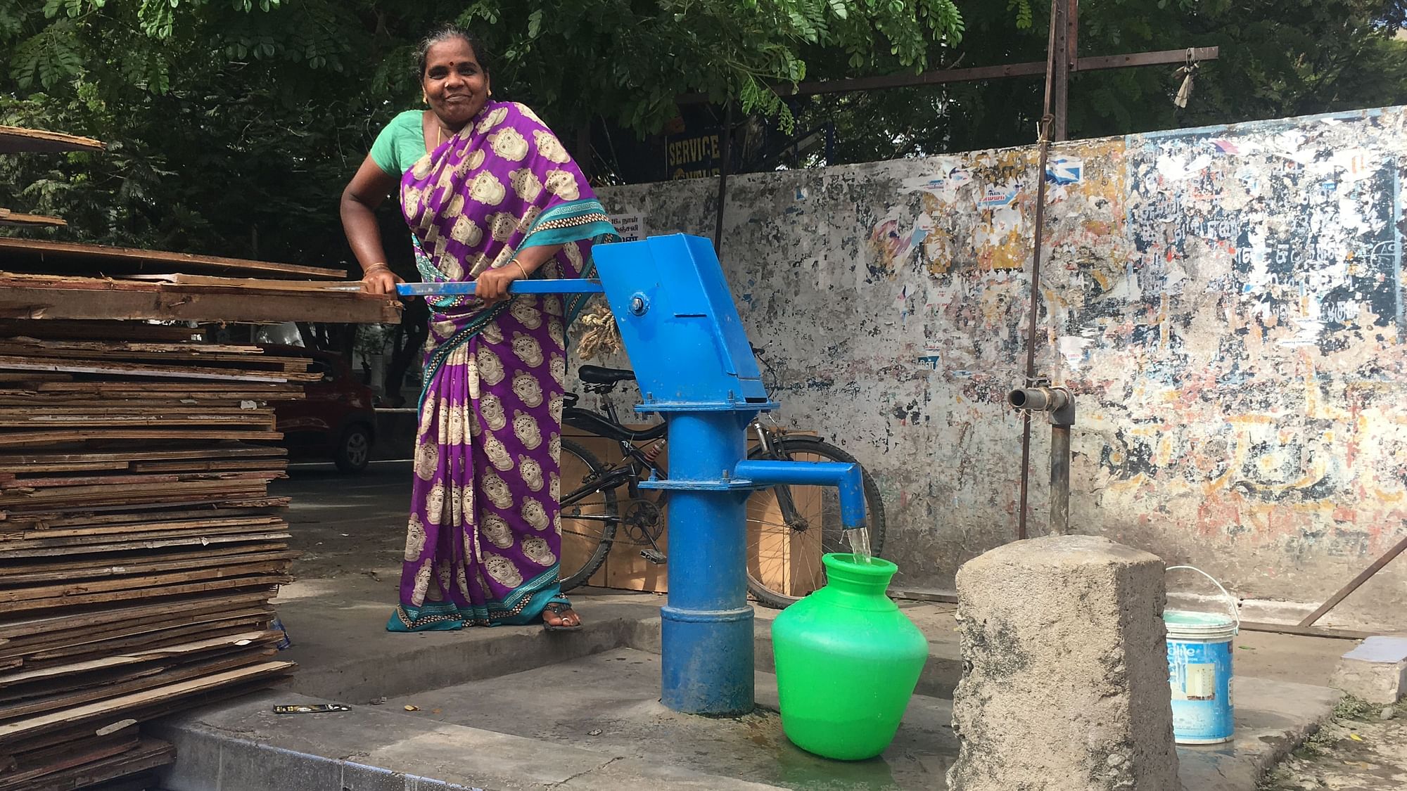 Saroja pumps water near her home in Badrikarai.