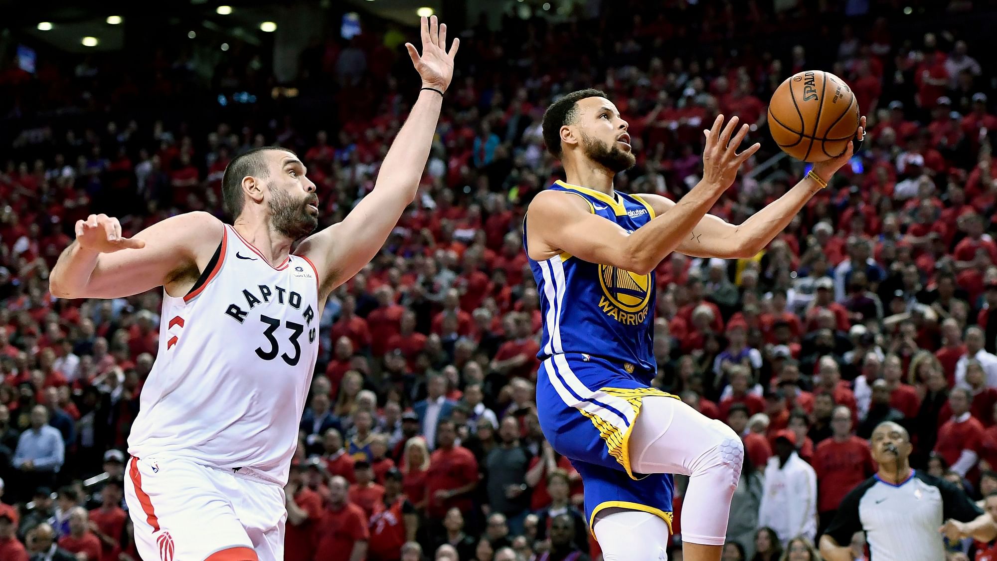 Golden State Warriors guard Stephen Curry (30) drives to the net as Toronto Raptors center Marc Gasol (33) looks on during the NBA Finals.