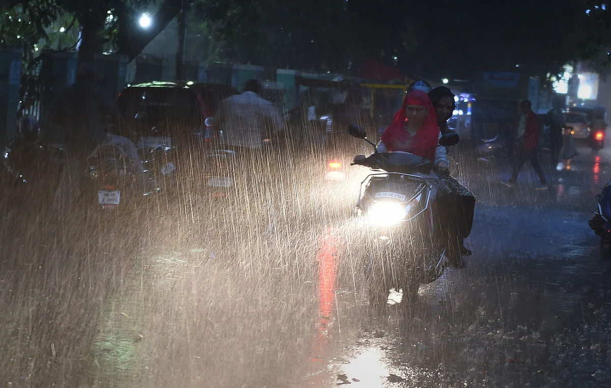 Commuters ride during sudden rain, providing respite after a prolonged dry and hot spell, in Chennai, on 26 June.